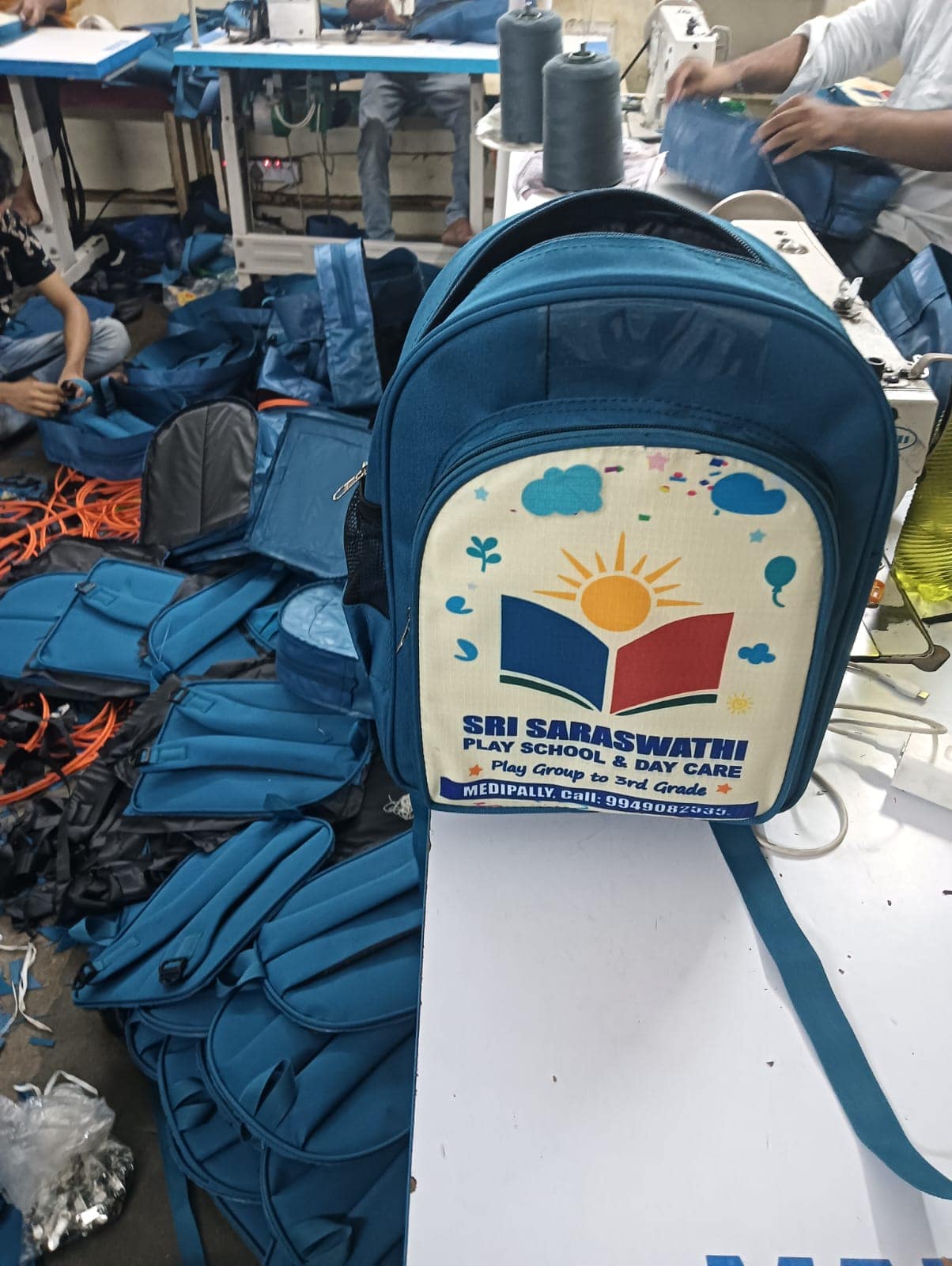 A branded backpack on the production floor, part of a run being stitched
